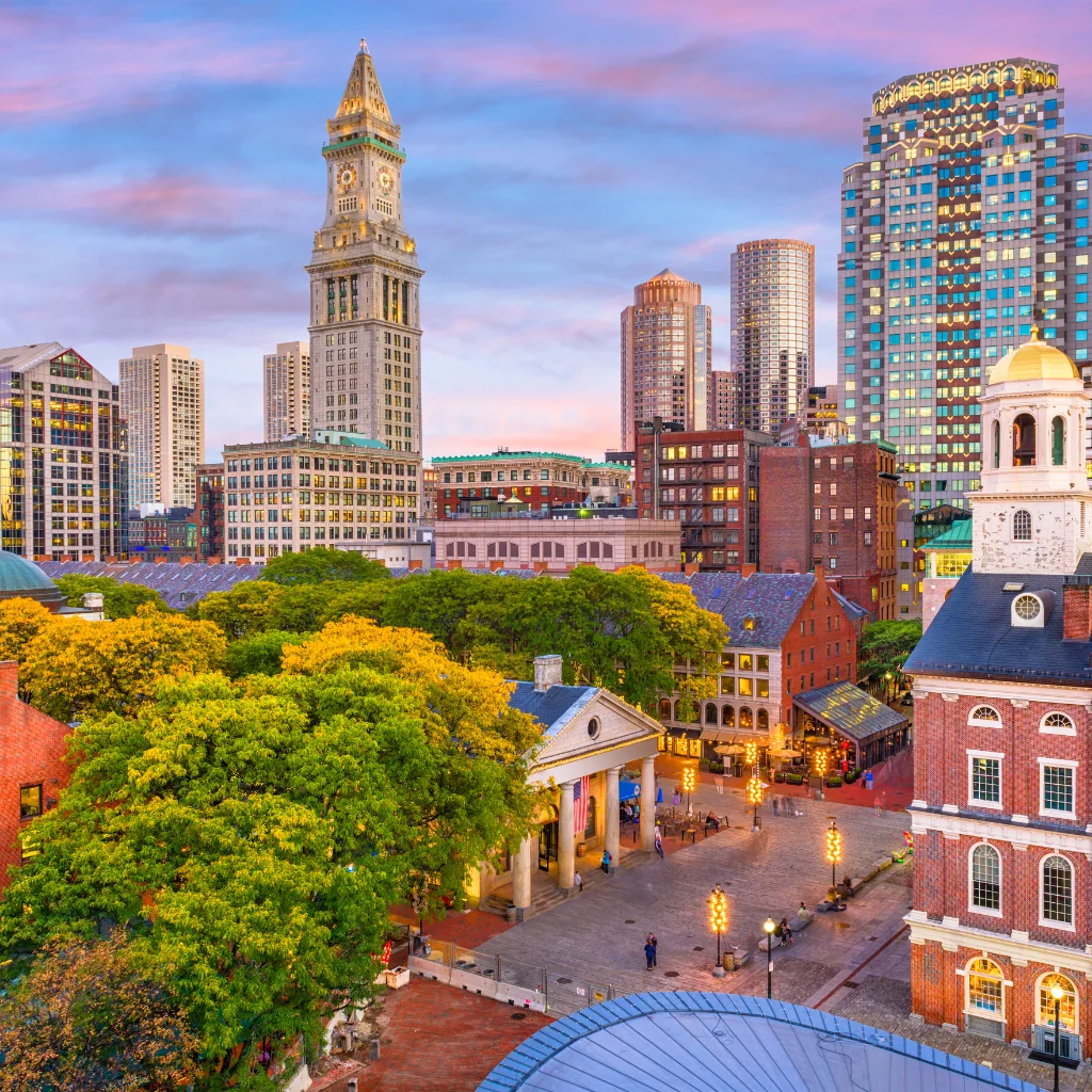Boston skyline with historic Quincy Market and Custom House Tower at sunset. Massachusetts / Transportvibe