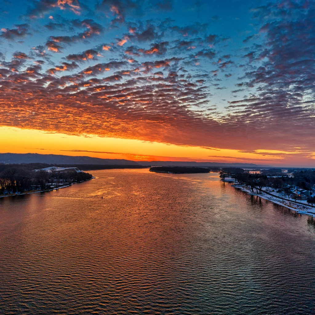 Mississippi River in Minnesota at sunset with a vibrant sky and calm waters. Transportvibe