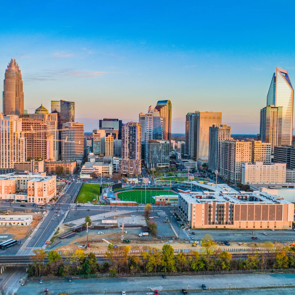 Charlotte skyline in North Carolina with modern skyscrapers and a clear sky. Transportvibe