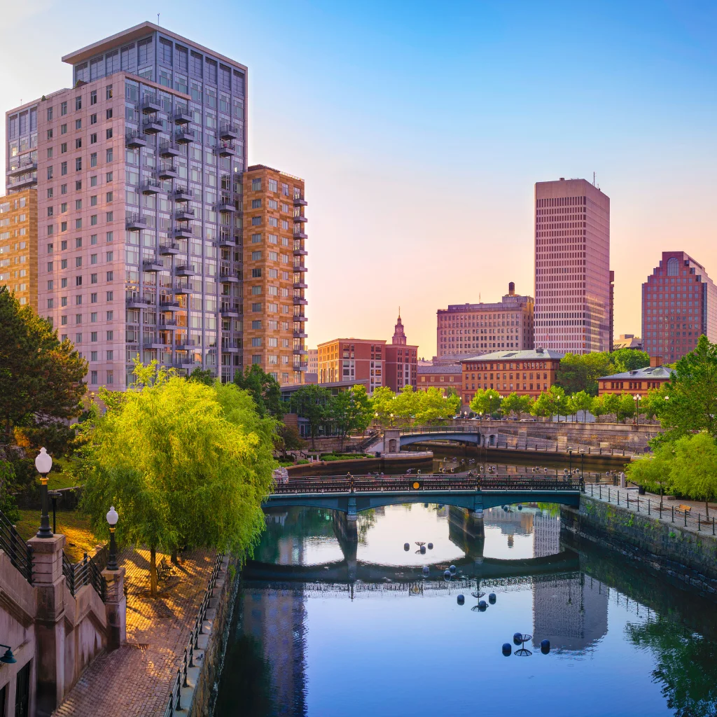 Providence skyline with river reflections and modern buildings at sunset. / Rhode Island / Transportvibe