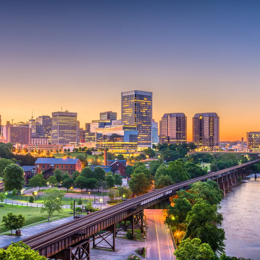 Richmond virginia skyline at dusk with city lights and a scenic river view. Transportvibe