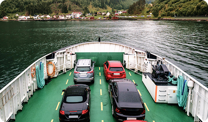 A large blue cargo ship loaded with colorful shipping containers sailing across the open sea with another vessel in the background. Transportvibe 2